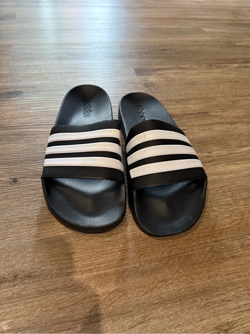 Adidas women’s Black Slide Sandals with White Stripes